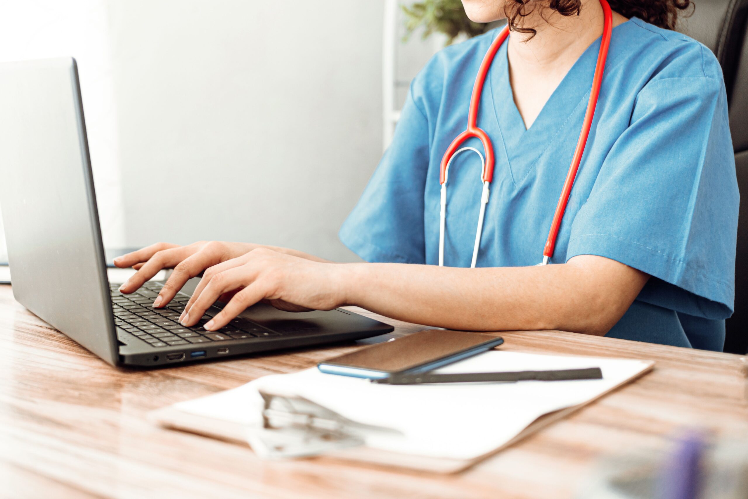 Healthcare professional using a laptop in a clinical workflow